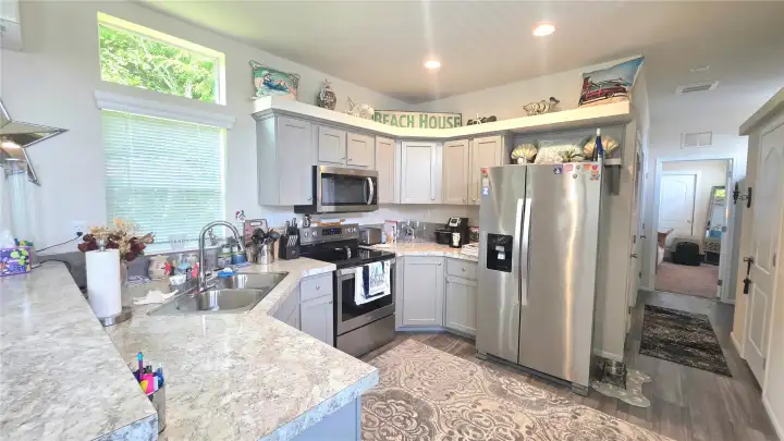 Open space to move around in the kitchen - all appliances included!  Hallway leads you down to bathroom and bedroom (and side door)