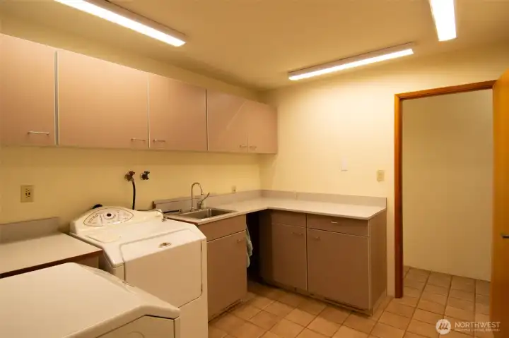 Loads of storage and folding space in laundry with utility sink