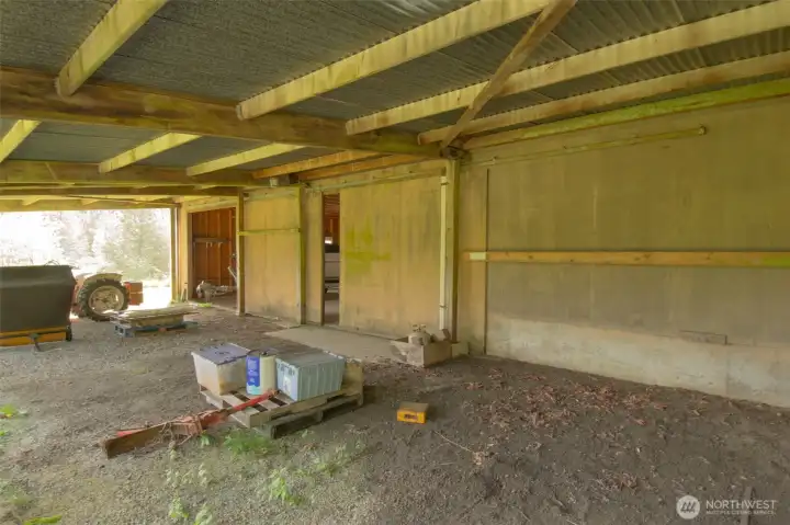 Sliding garage doors and covered area in back of shop includes 20 ft deep lean to with one bay enclosure.