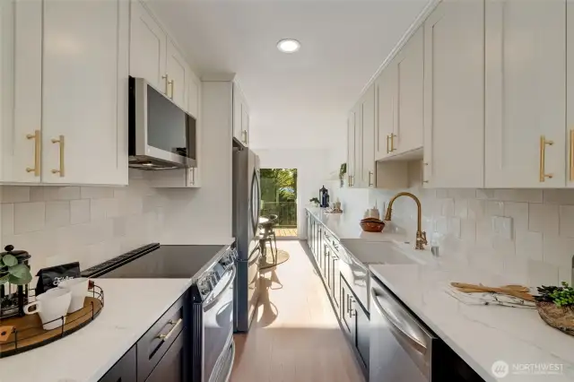 This spacious galley kitchen was completely renovated with all new materials and design. Featuring slab quartz, brushed brass hardware and plumbing fixtures, bedrosian tile backsplash, gorgeous appliance package and new flooring. Full heigh cabinets to ceiling for extra storage and luxurious look.
