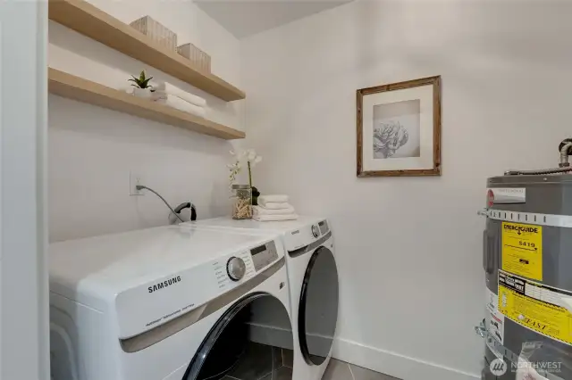 In Unit Laundry room with brand new Washer and Dryer as well as floating shelving and wash basin.