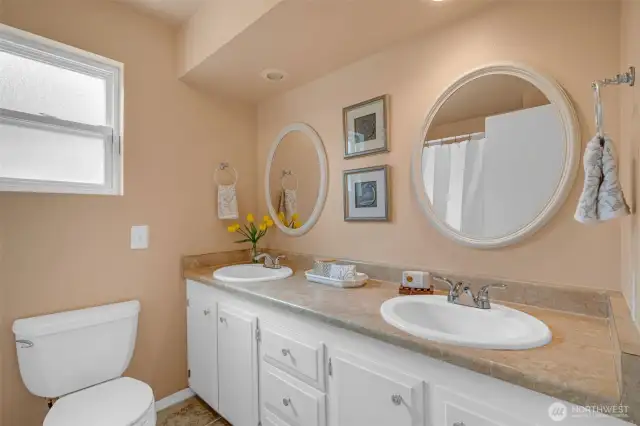 Hall bathroom with a double sink and tub/shower combo