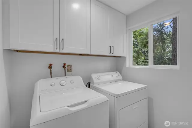 Laundry room with brand new cabinets and a pocket door to hide the noise