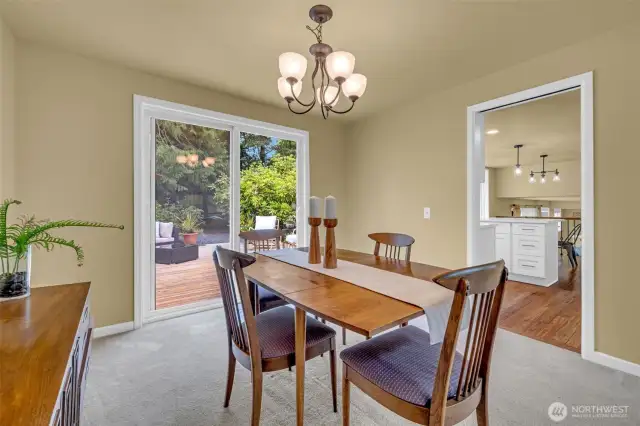 View from dining room with slider deck in the background and kitchen to the right