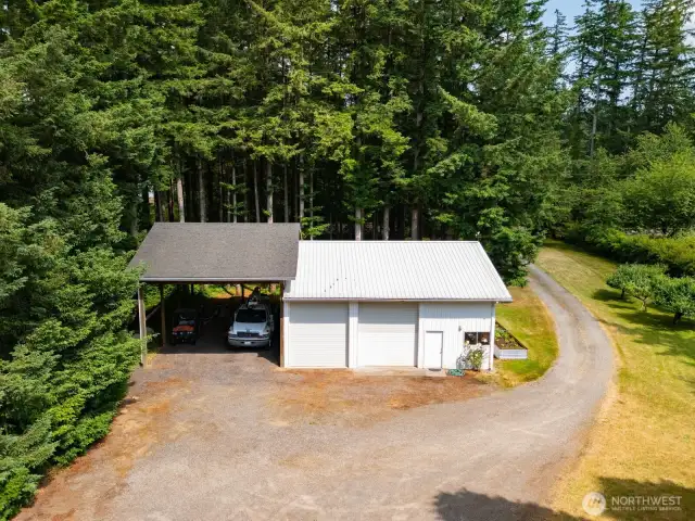 There is a lovely 2 bay shop with a work area and a large 2 vehicle (can accommodate most RV's) between the home and the road. There is a large raised bed with fresh vegetables.