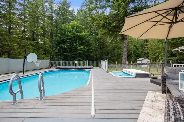 This pool is awesome! The deck wraps around the pool and the stairs are removable so that the cover can glide over to close it off. There is also a hot tub built in. Beyond the hot tub is a chicken coop and good shed.