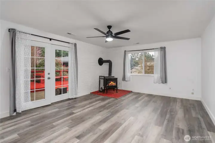Huge recreation room with wood stove and French doors leading outdoors.