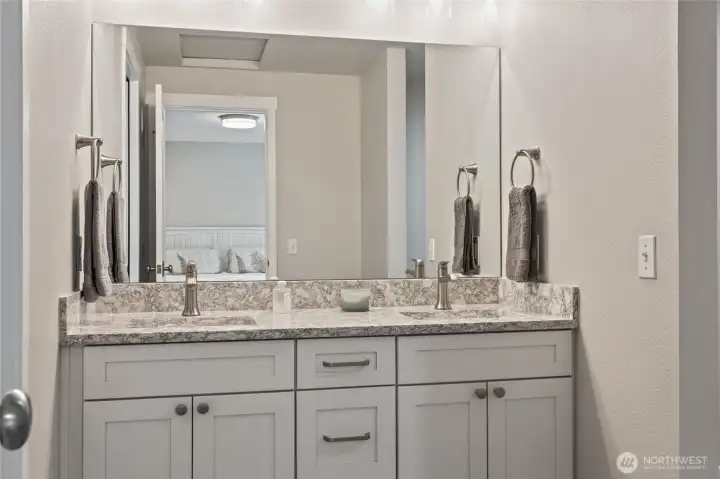 Double sinks in primary bathroom. Walk in closet is to the right.