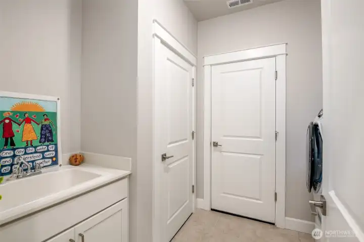 The laundry room is conveniently located between the kitchen and the garage.