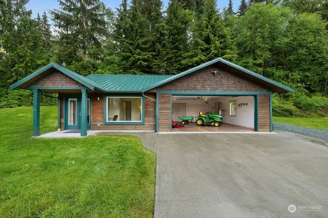 Outbuilding with 2 car garage. Cost $220,000. John Deer mower pictured in the garage is included with the home.