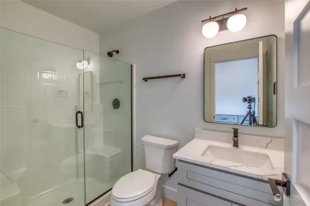 The first-floor bathroom features a shower and a quartz vanity countertop.