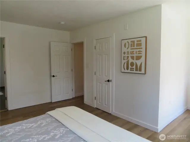 Enter into a large primary bedroom with many windows, faces the front and the west side of the home .