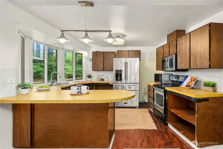 The kitchen has plenty of space and lots of windows to keep it bright. Most cabinet doors were removed by owner. Bring your ideas to refresh!