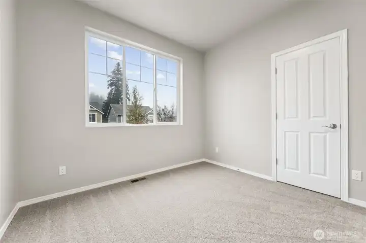 Bedroom #2 keeps things calm and versatile. Soft oatmeal carpeting warms the space, while the large front facing window with upper accent panels brings in natural light and a little architectural interest. High ceilings give the room breathing room, and the neutral palette makes it easy to style without committing to anything trendy. Every bedroom gets its own walk in closet here, which feels like a small luxury you quickly stop wanting to live without. Located in the Olympic View Elementary, Nisqually Middle, and River Ridge High school zones, this room works just as well for kids, guests, or upstairs den.