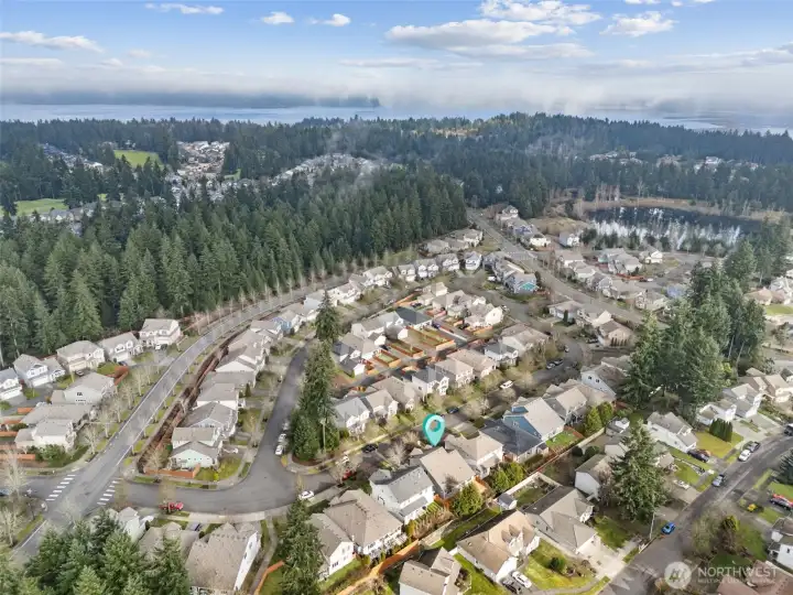 This view captures the bigger picture. Tree lined streets anchor the neighborhood, and in the distance you catch a glimpse of the water at Hogum Bay, a subtle reminder that you’re never far from nature here. Golf courses and hiking trails are close enough to make spontaneous plans realistic, and favorite local eateries and shops are right within reach. It’s a location that balances everyday convenience with those small scenic moments that make coming home feel good.