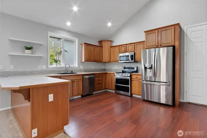 Rich flooring and clean lines give the kitchen a timeless feel. Ample prep space and smart layout make it as functional as it is welcoming.