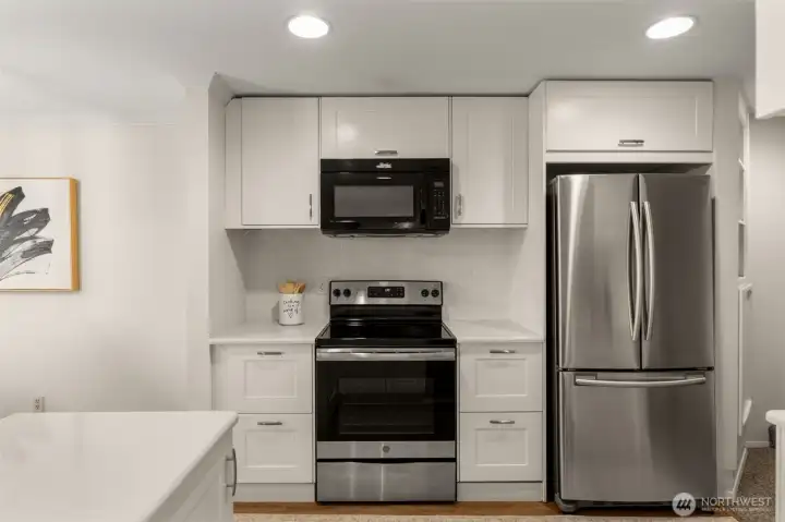 Updated kitchen with stainless steel appliances and tiled backsplash.