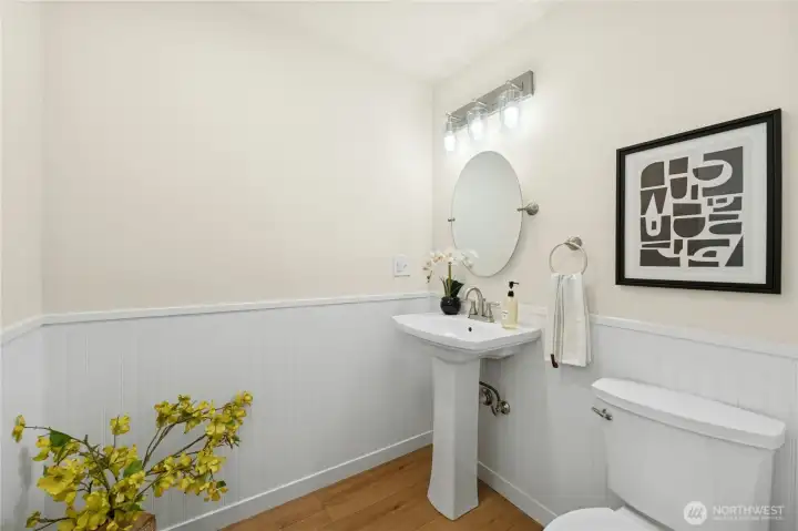 Main floor powder room just off the entry has been updated with new fixtures and lighting.