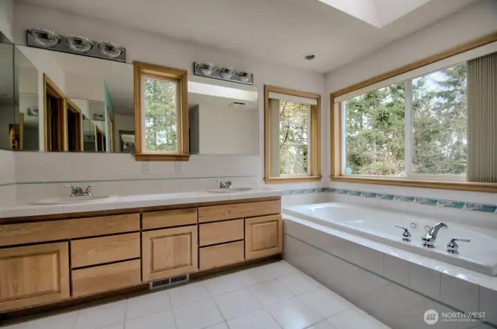 Heated tile floors, small hot water tank to allow for quick hot water, windows over the tile jetted tub.