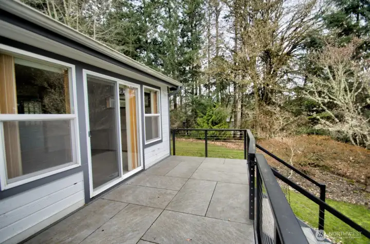 Deck along the back of the home overlooks the sloped lot and features seasonal view of the Nisqually Reach.