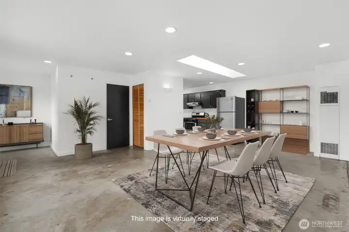 Large open concept living with industrial style concrete flooring. This photo has been virtually staged.