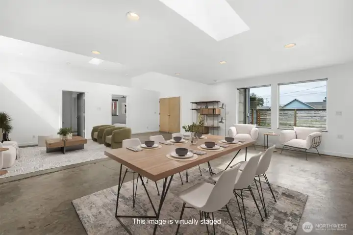 Large open concept living with industrial style concrete flooring. This photo has been virtually staged.