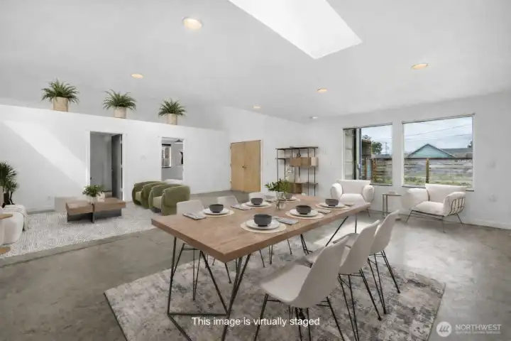 Large open concept living with industrial style concrete flooring. This photo has been virtually staged.
