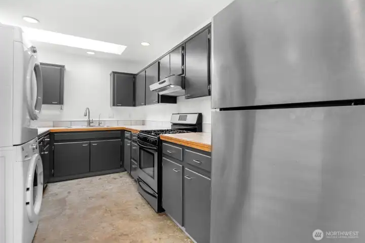 Kitchen area with stackable washer and dryer. This unit can be moved.