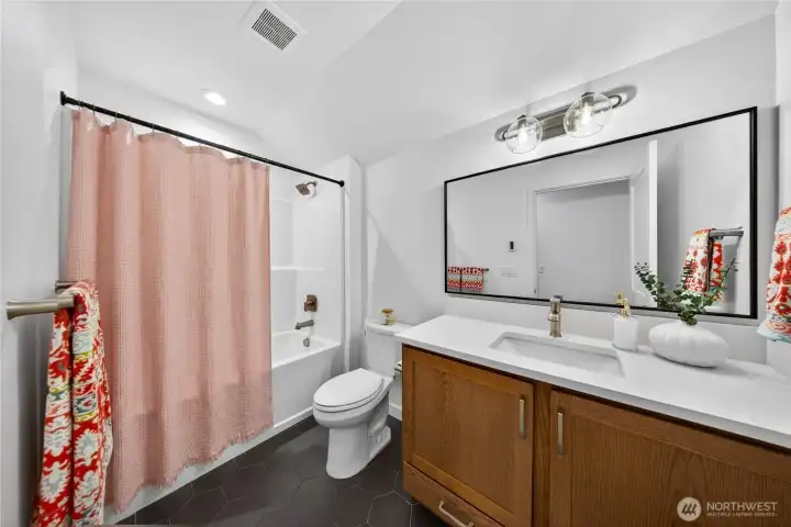 Upstairs full bath with tile floors and oversized vanity.