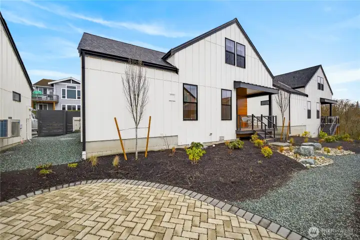 Additional view shows the cottage with the community patio and walking trail.