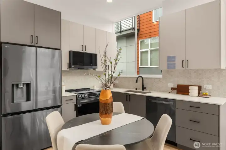 Color-blocked cabinetry, quartz counters, and matte black finishes = total chef’s kiss.