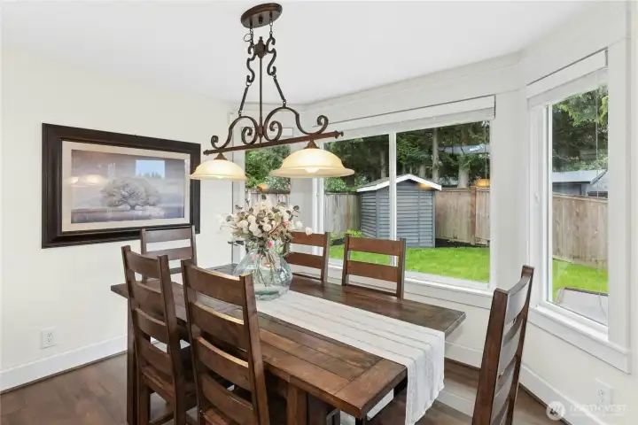 Bright dining area surrounded by windows and natural light with backyard views, ideal for everyday living and hosting gatherings.