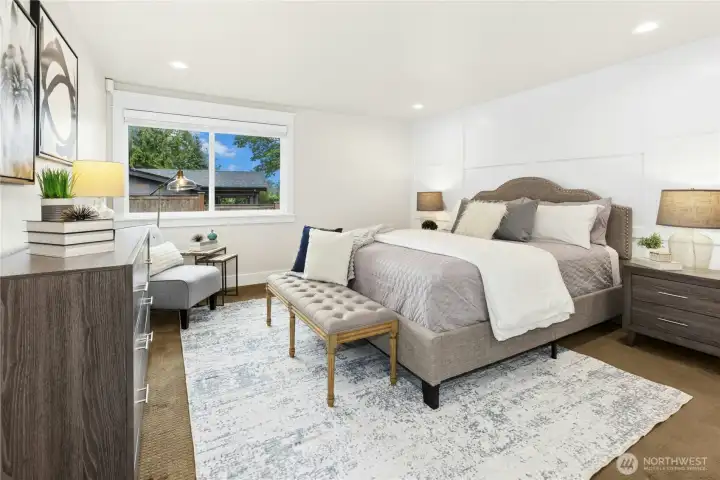 Generously sized primary suite with custom accent wall, designer finishes, recessed lighting, and peaceful retreat-style ambiance.