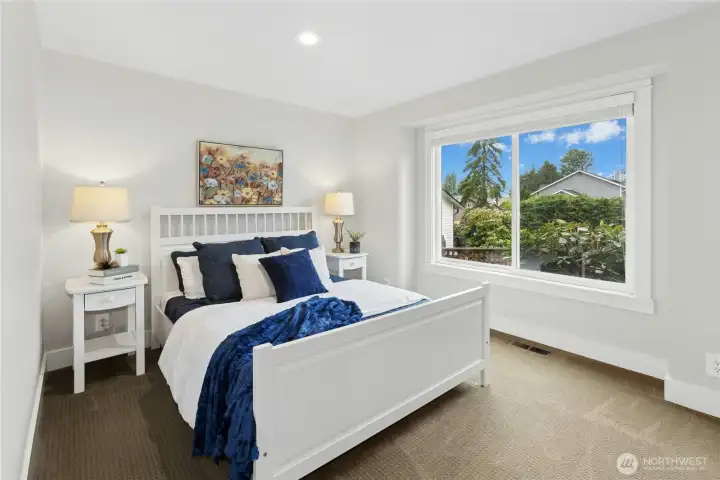 Generously sized secondary bedroom with oversized picture window, plush carpet, recessed lighting, and bright neutral finishes.