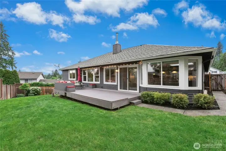 Large entertainment deck overlooking the beautifully landscaped backyard — perfect for summer gatherings, outdoor dining, and relaxing evenings