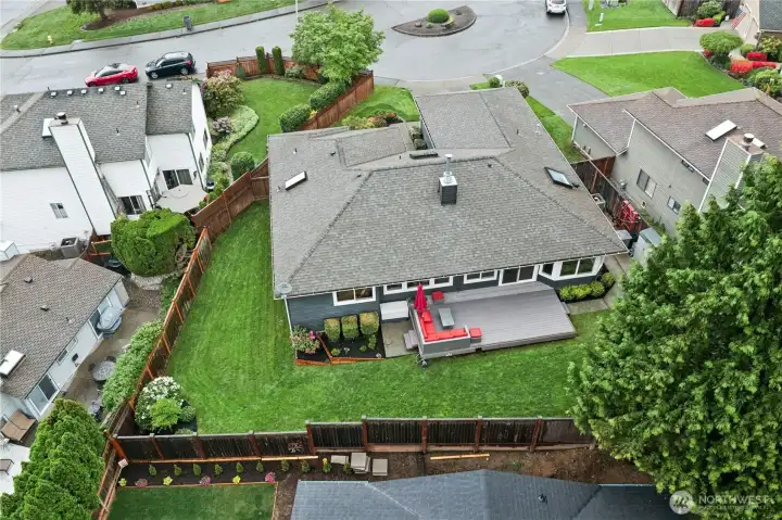 Backyard Aerial View  Exceptional outdoor space with large entertainment deck, manicured lawn, and excellent privacy surrounded by mature trees.