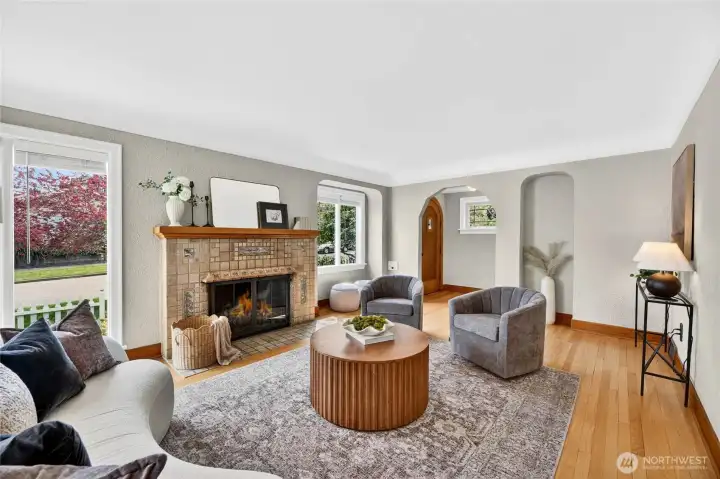The large living room with hardwood floors and gas fireplace features archways and double-paned windows allowing an abundance of natural light into this gracious home.
