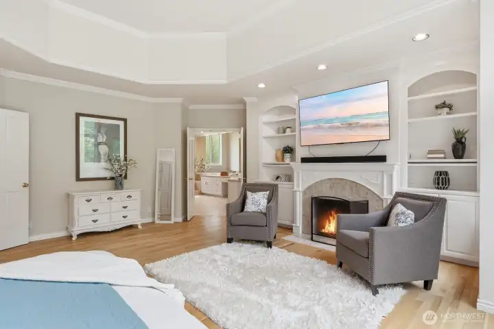 Primary suite on main floor with marble fireplace flanked with built-ins.