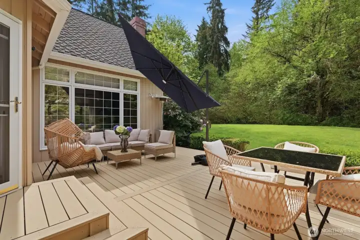 Outdoors, the sun-drenched grounds provide a serene escape, backing to a lush greenbelt and featuring vibrant emerald lawns and a newer low-maintenance TimberTech deck—perfect for relaxing or entertaining in total privacy.