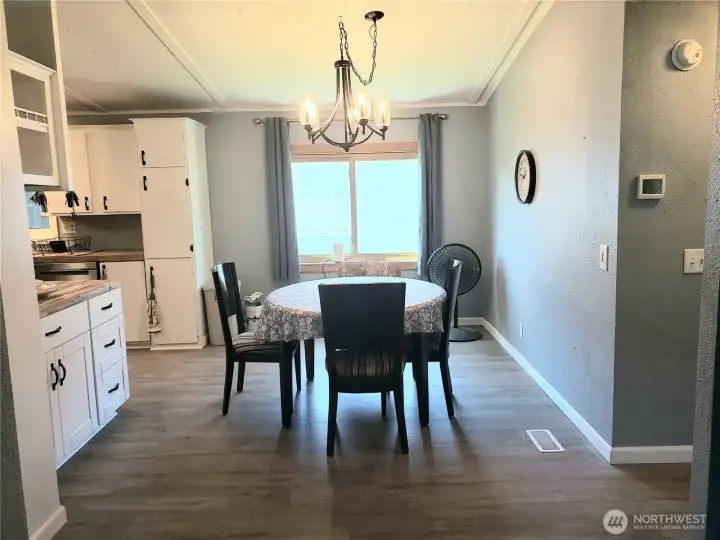 A Close Up Picture of the Dining Room Showing White Painted Trim and Vinyl Plank Flooring.