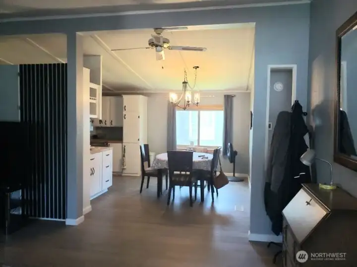A Picture of the Dining Room Showing New White Painted Trim and Vinyl Plank Flooring.