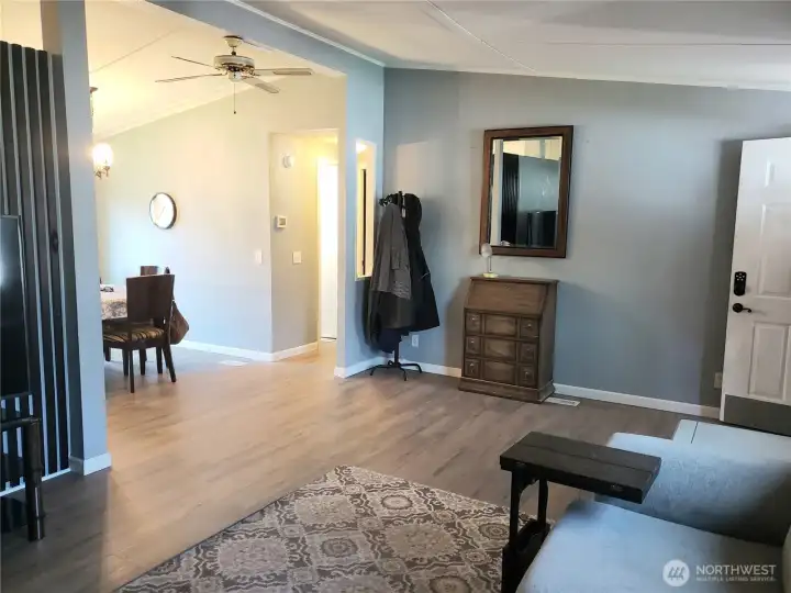 Another Picture from the Huge Living Room Looking into the Living Room and Front Entry Door Showing New Interior Paint, White Painted Trim and Vinyl Plank Flooring.