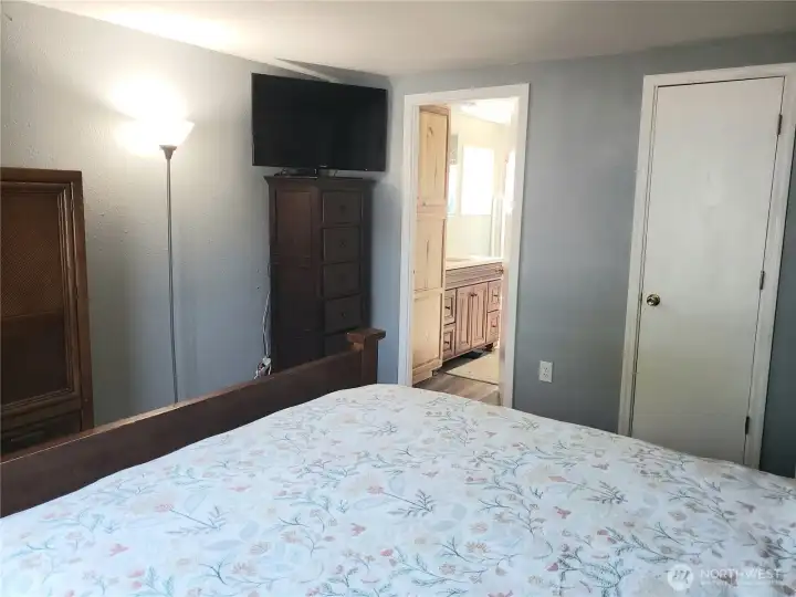 A Different View of the A Huge Primary Master Bedroom Showing New Interior Paint, White Painted Trim and Vinyl Plank Flooring Looking into the Primary Bathroom.