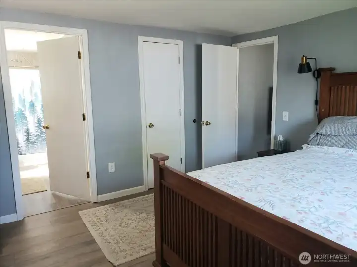A Different View of the A Huge Primary Master Bedroom Showing New Interior Paint, White Painted Trim and Vinyl Plank Flooring Looking into the Primary Bathroom.
