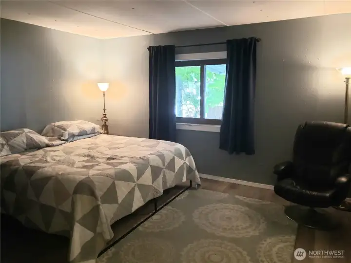 A Picture of the Large Second Bedroom Showing New Interior Paint, White Painted Trim and Vinyl Plank Flooring.