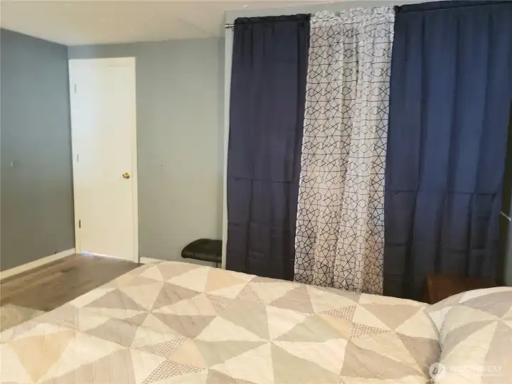Another Picture of the Large Second Bedroom Showing New Interior Paint, White Painted Trim and Vinyl Plank Flooring.