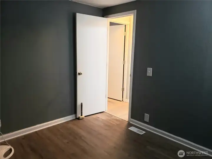 A Picture of the Nice Size Third Bedroom Showing New Interior Paint, White Painted Trim and Vinyl Plank Flooring.