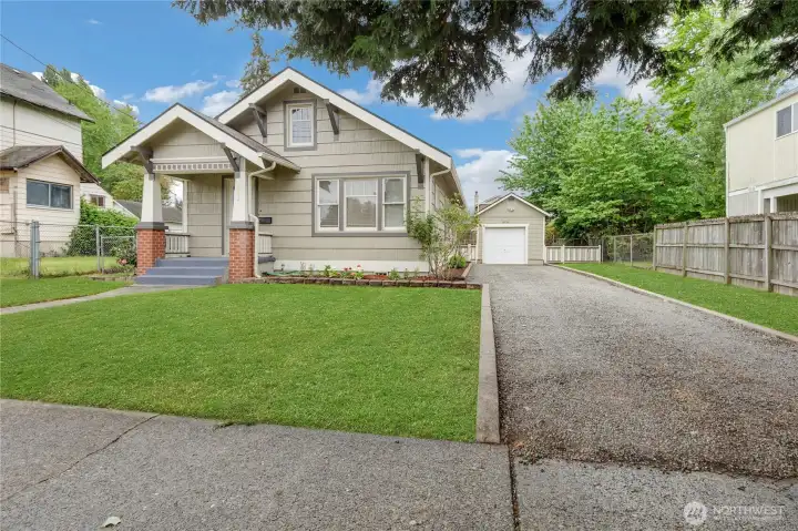 Front of home with detached garage. Grass was photoshopped.