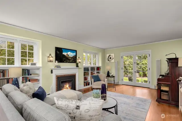 Light filled living room with cozy gas fireplace and & original built in bookcases.