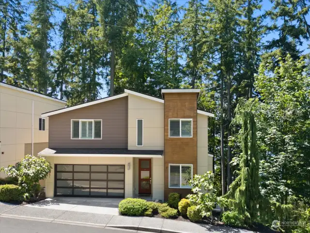 Front view of home adjacent to open space.